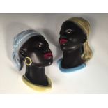 A pair of Cortendorf wall masks, each modelled as a young black woman, stamped and impressed