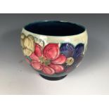 A Moorcroft Clematis pattern planter, the bulbous form raised on a small circular foot, decorated on