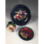 Three small Moorcroft pieces, comprising an Orchid pattern plate, an Hibiscus pattern dish and a