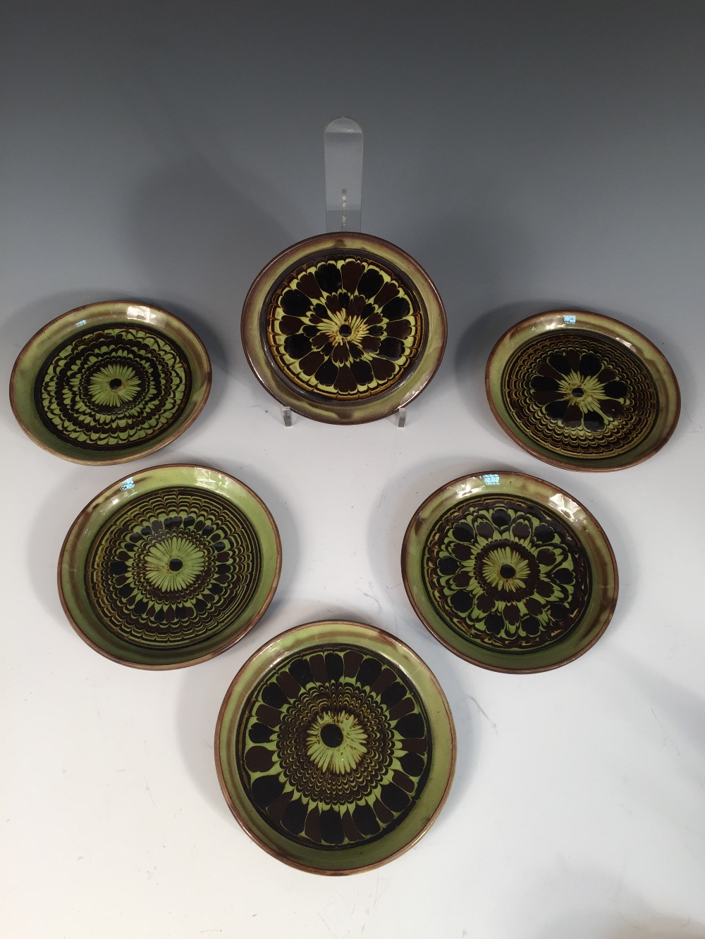 Sidney Tustin for Winchcombe Pottery, a set of six slipware side plates, each of circular form