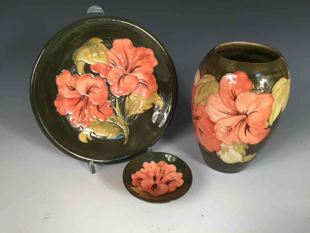 A small collection of Moorcroft Hibiscus pattern wares, comprising a vase, plate and pin dish, all