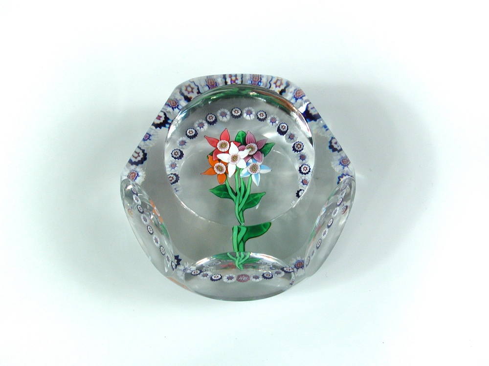 A modern St Louis facet cut glass paperweight, with central lampwork nosegay and garland