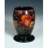 A Moorcroft leaves and fruit pattern flambé vase, the goblet form with spreading circular foot,