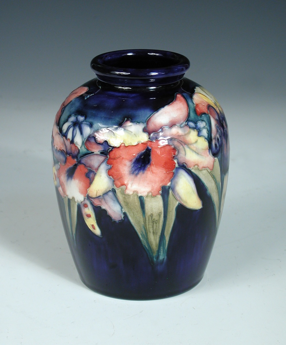 A Moorcroft Orchid pattern vase, the globular form decorated to a deep blue ground, painted,
