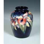 A Moorcroft Orchid pattern vase, the globular form decorated to a deep blue ground, painted,