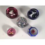 Five assorted Perthshire glass paperweights, including a scrambled millefiori weight dated 1975, two