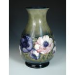 A large Moorcroft Anemone pattern vase, the baluster form decorated to a green ground, painted and