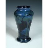A Moorcroft Moonlit Blue pattern vase, the inverted baluster form decorated to a deep blue ground,