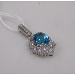 A topaz and cubic zirconia pendant, the oval blue topaz surrounded by pear shaped and round CZ and