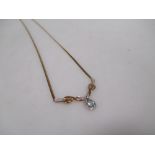 A 9ct topaz and diamond necklace, the pear shaped topaz set in a white metal surround set with a