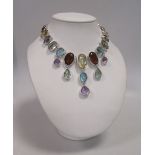 A multi gemset necklace, the graduated oval, round, cushion and pear shaped stones comprising of