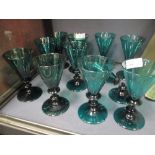 A set of ten green drinking glasses