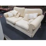 A two seat cream upholstered sofa