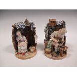 A pair of continental figurines of a cobbler and his wife, seated beneath a song bird in a cage 27cm