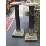 A pair of marble topped and ebonised columns, 103cm high