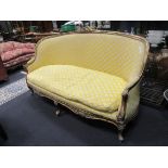 A Louis XV style giltwood three seater sofa, upholstered in a geometric yellow fabric, 214cm wide