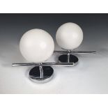 A pair of chrome wall lights, each with frosted glass globes to a chrome bar and circular back