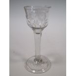 An 18th century wine glass with flower and bird engraved bowl, the clear stem on folded foot, 15cm