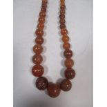 A reconstituted amber bead necklace and other rust brown amber beads