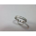 An 18ct white gold and white hardstone full hoop eternity ring, the step cut stones channel set to