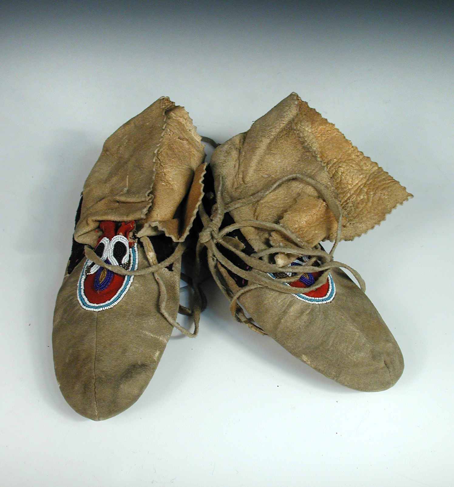 A pair of Plains Indian leather moccasins, with bead worked uppers