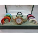 A Gucci watch with multi-coloured interchangeable bezels, the circular white face without