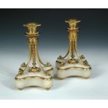 A pair of 19th century French ormolu candlesticks, the gadrooned nozzles above a central wrythen