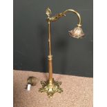 A gilt brass table lamp, the scrolling arm above plain and fluted column supported on a spreading
