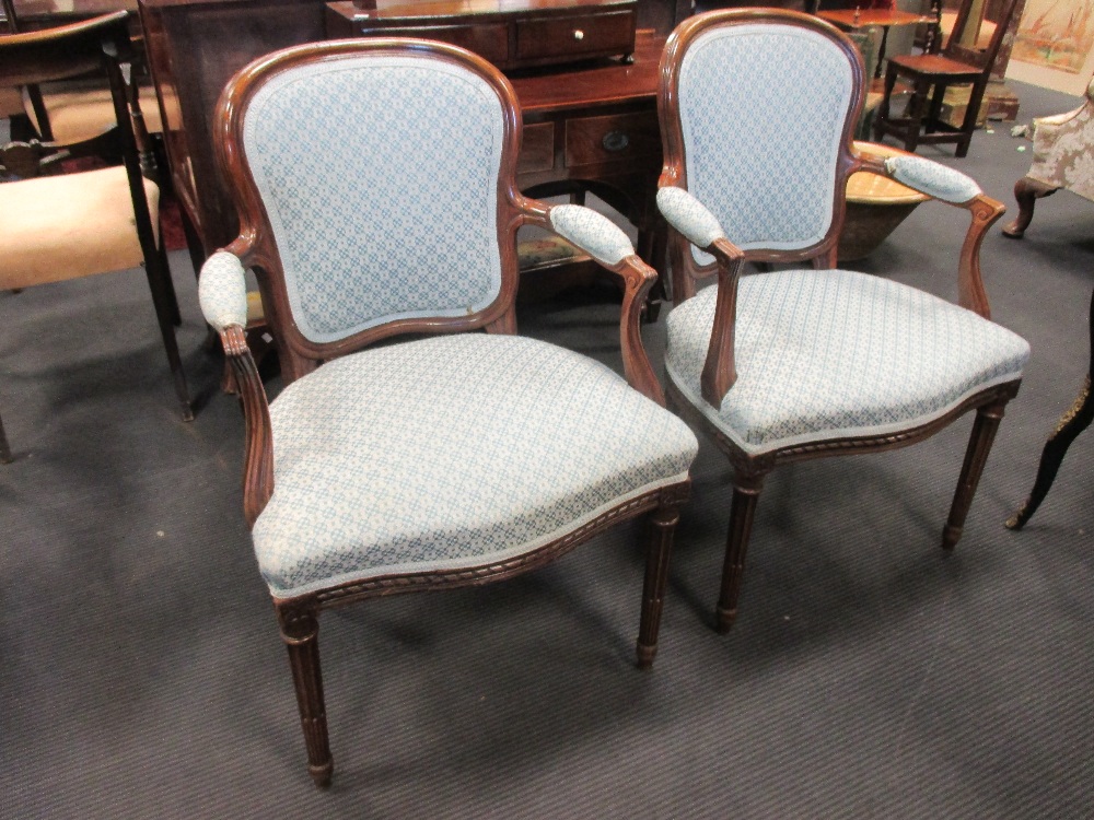 A pair of old reproduction mahogany open armchairs in the French style