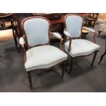 A pair of old reproduction mahogany open armchairs in the French style