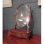 A George III mahogany swing mirror with serpentine base