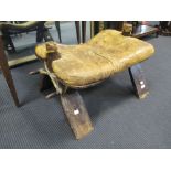 A leather upholstered camel saddle from the collection of the Late Christopher Hogwood CBE, 64cm