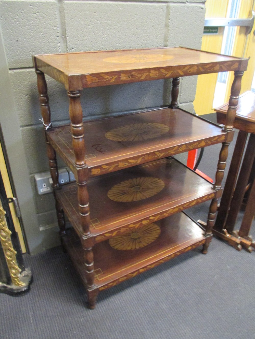 An early 19th century Dutch mahogany and inlaid four tier etagiere inlaid with trailing leaf borders