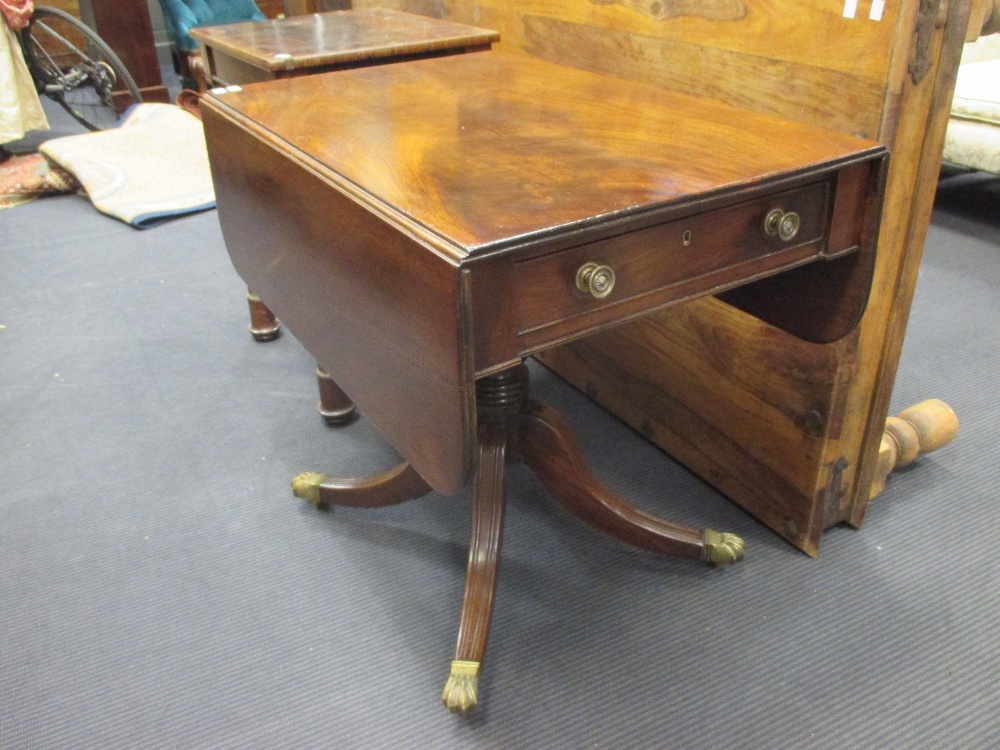 A Regency mahogany pedestal Pembroke table, fitted with a drawer, on four swept legs and brass paw