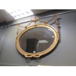 A 19th century oval gilt framed wall mirror with urn and swag decoration