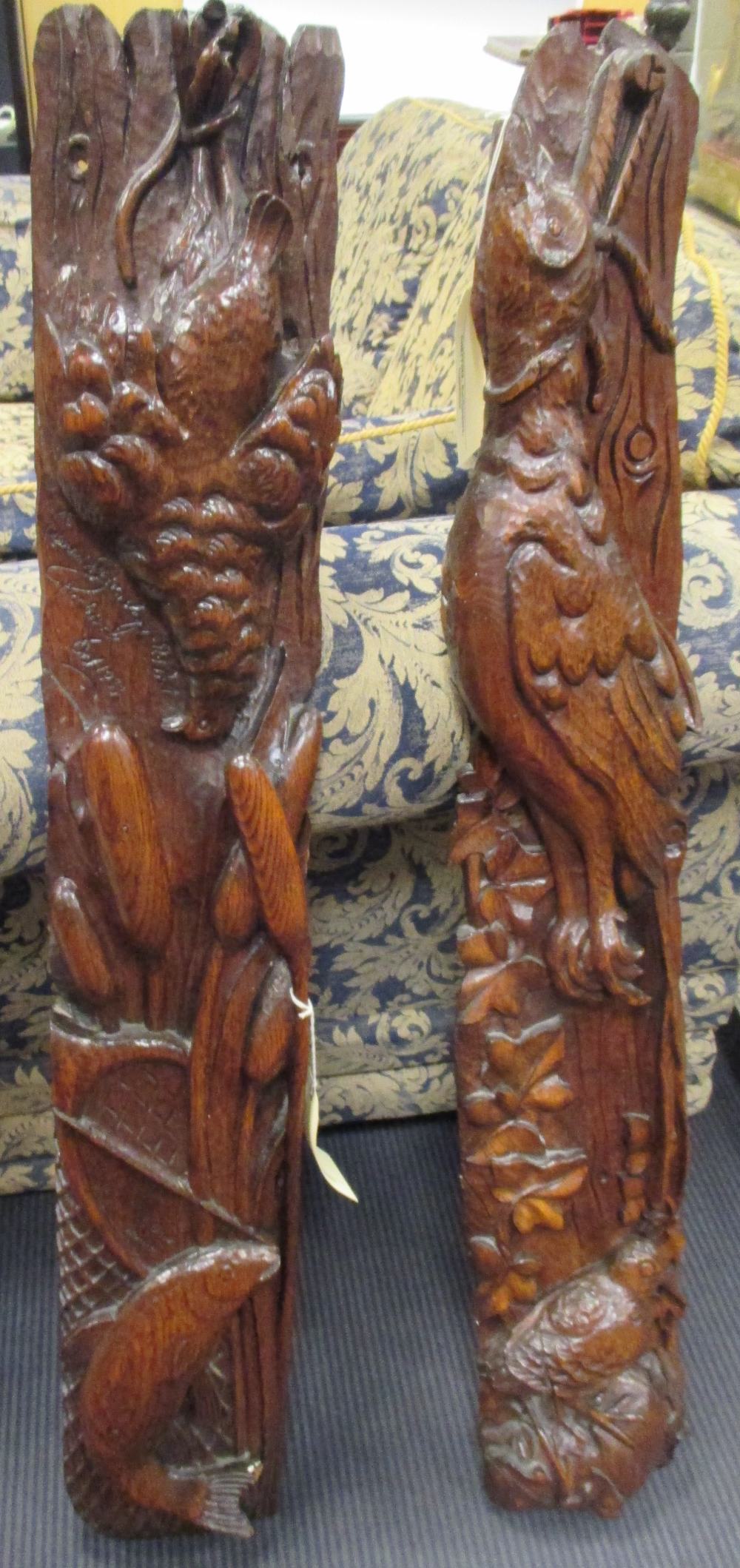 Two 20th century oak carved panels, one of a pheasant and curlew amongst ivy and the other of fish