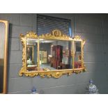 A triple plate overmantel mirror within a scroll, shell and rocaille moulded gilt frame