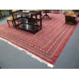 A large modern Persian Bokhara patterned carpet, 550 x 372cm