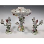 A Dresden floral encrusted porcelain fruit stand with amorini and a pair of similar three-light