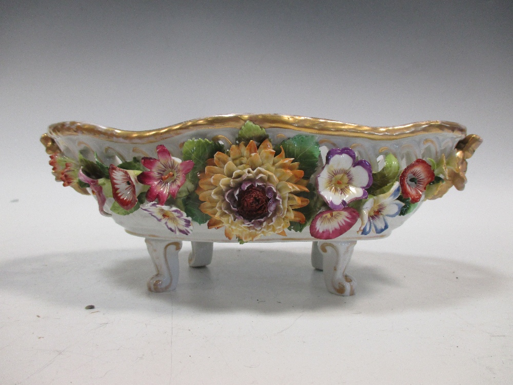 A Dresden floral encrusted porcelain fruit stand of shaped oval form with gilded border on scroll