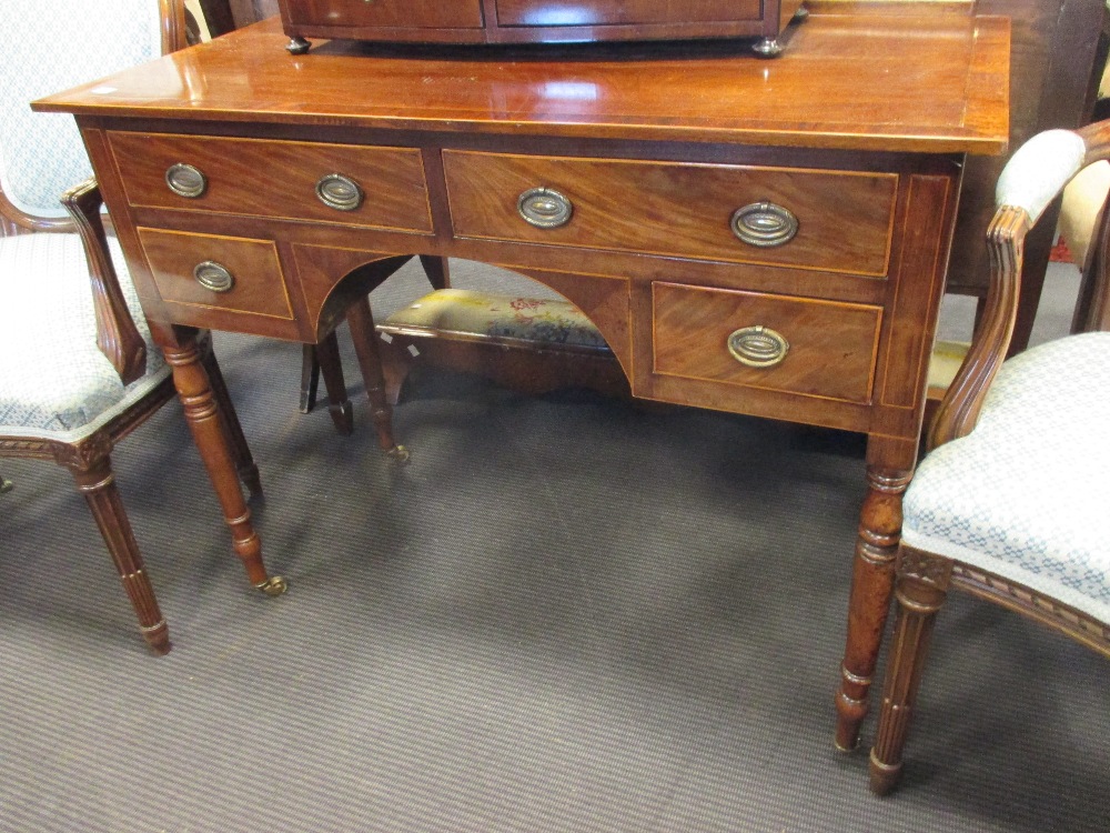 A Regency mahogany kneehole dressing table fitted with two long and two short drawers on turned legs