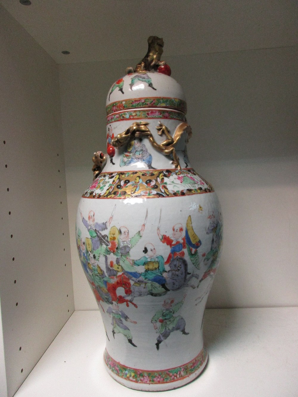 A 19th century Canton vase and cover, the baluster shape painted with a mock battle between horsemen