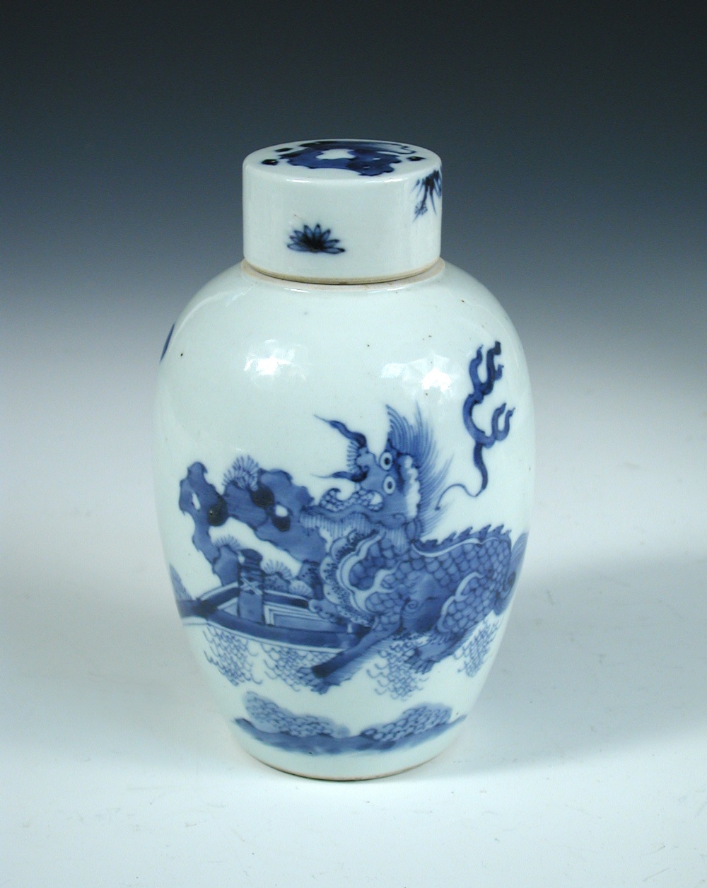 An 18th century blue and white covered jar, the pill box cover painted in Kangxi style with a