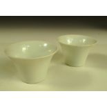Two 19th century white glazed cups, each of the flared sides with anhua decoration of lotus, the