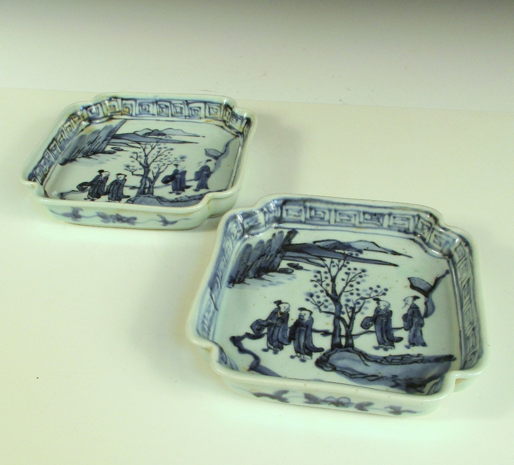 A pair of 19th century Korean blue and white square dishes, each painted with four figures walking