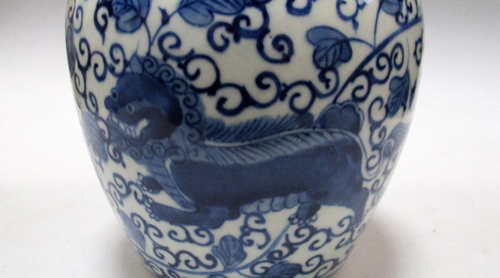 A Transitional style blue and white jar, painted with two Buddhist lions running against flowering - Image 4 of 4