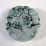 A dark green mottled jadeite pendant, the disc shape carved with a qilin on a sycee ingot, the