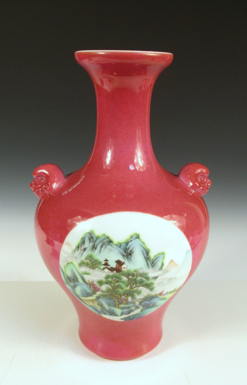 A Republic Period vase, the pronounced shoulders of the baluster shape supporting mask handles,