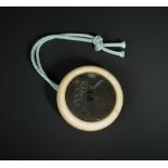 A 19th century kagamibuta by Hiroaki, the cording attached to a shibuichi plate through an ivory