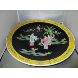 An early 20th century famille noire charger painted with two ladies accompanied by a boy as they